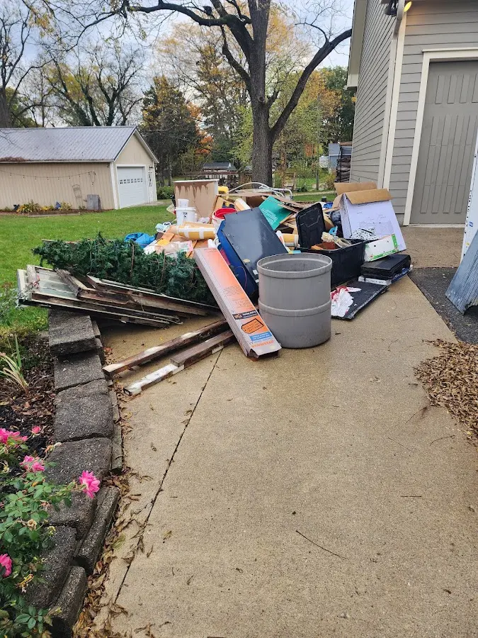 Dumpster being loaded with debris for 12 Yard Dumpster Rental in Roselawn